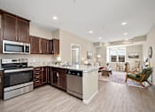 Thumbnail 3 of 44 - A kitchen with brown cabinets and stainless steel appliances at The Winslow 62+ Apartments, Minnesota, 55118
