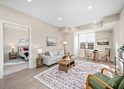 Thumbnail 7 of 44 - A living room with a white couch, a coffee table, and a rug at The Winslow 62+ Apartments, West St Paul, MN