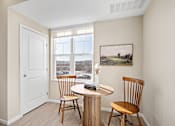 Thumbnail 6 of 44 - A room with a table and chairs and a painting on the wall at The Winslow 62+ Apartments, West St Paul, MN, 55118