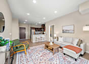 Thumbnail 1 of 44 - A living room with a rug on the floor and a couch with pillows at The Winslow 62+ Apartments, West St Paul, 55118