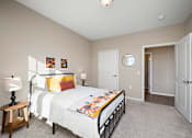 Thumbnail 13 of 44 - A bedroom with a bed, a nightstand, and a mirror at The Winslow 62+ Apartments, West St Paul, 55118
