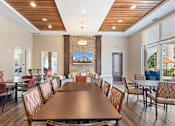 Thumbnail 36 of 44 - a dining room with a table and chairs and a fireplace at The Winslow 62+ Apartments, West St Paul, MN, 55118