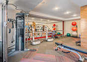 Thumbnail 39 of 44 - a gym with cardio equipment and weights on the floor at The Winslow 62+ Apartments, West St Paul, 55118