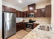 Thumbnail 22 of 44 - a kitchen with stainless steel appliances and marble counter tops at The Winslow 62+ Apartments, West St Paul