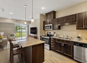 Thumbnail 21 of 44 - an open kitchen and living room with a table and chairs at The Winslow 62+ Apartments, West St Paul, Minnesota
