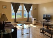 Thumbnail 2 of 57 - a living room with a couch and a table and a television