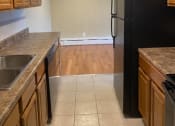 Thumbnail 6 of 57 - a kitchen with wooden cabinets and a black refrigerator