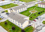Thumbnail 57 of 57 - A large building complex with a parking lot in front.