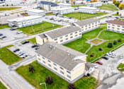 Thumbnail 54 of 57 - A large building complex with a parking lot in front.