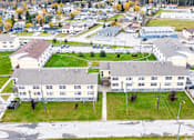 Thumbnail 53 of 57 - A large building complex with a parking lot in front.