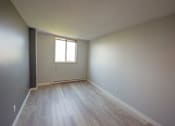 Thumbnail 6 of 17 - A room with a window and wooden flooring.