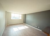 Thumbnail 11 of 17 - A room with a window and wooden flooring.