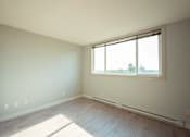 Thumbnail 12 of 17 - A room with a window and a wooden floor.