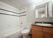 Thumbnail 17 of 17 - A bathroom with a white toilet, a bathtub, and a sink.