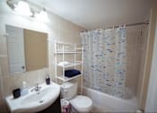 Thumbnail 12 of 57 - A bathroom with a sink, toilet, and shower.