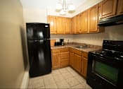 Thumbnail 19 of 57 - A kitchen with black appliances and wooden cabinets.