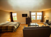 Thumbnail 17 of 57 - A bedroom with a bed, a couch, and a television.