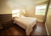 Thumbnail 16 of 57 - A bedroom with a bed, dresser, and window.