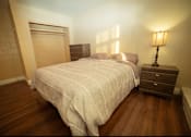 Thumbnail 24 of 57 - A bedroom with a bed, nightstand and lamp.