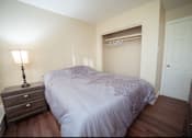 Thumbnail 21 of 57 - A bedroom with a bed, nightstand, and lamp.