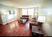 Thumbnail 27 of 57 - A living room with brown leather furniture and a wooden floor.