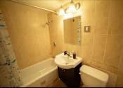 Thumbnail 28 of 57 - A bathroom with a white sink and a white toilet.