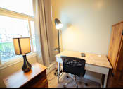 Thumbnail 36 of 57 - A desk with a chair and a lamp in a room.