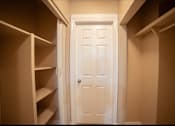 Thumbnail 37 of 57 - A white door is in a hallway with shelves on either side.