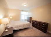 Thumbnail 47 of 57 - A bedroom with a bed, nightstand, and dresser.