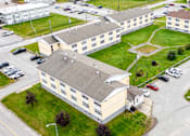 Thumbnail 4 of 28 - A large building with the word "SAN" on it is surrounded by a parking lot.