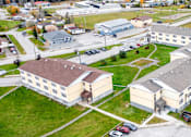 Thumbnail 5 of 28 - An aerial view of a large building complex with multiple buildings and parking lots.