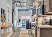 Thumbnail 20 of 71 - A modern kitchen with a view of the balcony outside.