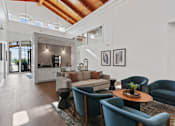 Thumbnail 58 of 83 - a living room with a vaulted ceiling and a kitchen in the background at Audenn Apartments, Bloomington, MN, 55438