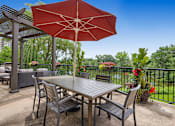 Thumbnail 33 of 49 - a patio with a table and chairs and a red umbrella