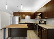Thumbnail 13 of 55 - A kitchen with a wooden island and stainless steel appliances.