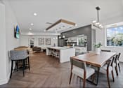 Thumbnail 65 of 83 - a dining area with a wooden table and chairs and a kitchen in the background at Audenn Apartments, Bloomington, Minnesota