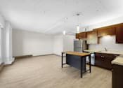 Thumbnail 18 of 55 - A kitchen with wooden cabinets and a table.