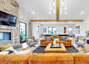 Thumbnail 68 of 113 - A living room with a stone fireplace and a large orange sofa.