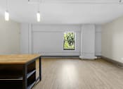 Thumbnail 20 of 55 - A room with a wooden table and a window.