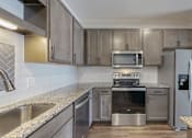 Thumbnail 27 of 32 - A modern kitchen with stainless steel appliances and wooden cabinets.