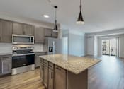 Thumbnail 26 of 32 - A modern kitchen with a granite countertop and stainless steel appliances.
