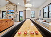 Thumbnail 39 of 52 - A shiny wooden table with red and white decorations is in the middle of a room with a stone fireplace and a large window.