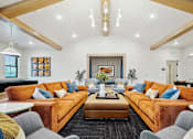 Thumbnail 36 of 52 - A living room with orange couches and a black rug.