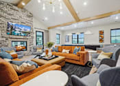 Thumbnail 37 of 52 - A living room with a stone fireplace and a large flat screen TV mounted above it.
