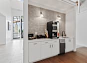Thumbnail 59 of 83 - a kitchen with white cabinets and a black coffeemaker at Audenn Apartments, Bloomington