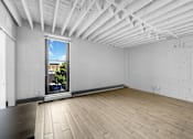 Thumbnail 7 of 55 - A room with a window and wooden flooring.