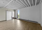 Thumbnail 27 of 55 - A room with wooden floors and white walls.