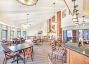 Thumbnail 25 of 49 - a large lobby with tables and chairs and a kitchen