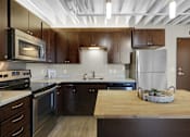 Thumbnail 25 of 55 - A kitchen with wooden cabinets and a refrigerator.