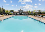 Thumbnail 70 of 83 - a swimming pool with lounge chairs and a building in the background at Audenn Apartments, Bloomington, MN